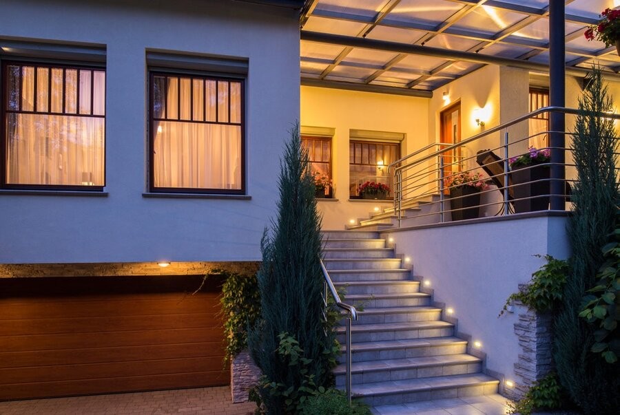 A patio illuminated by outdoor landscape lighting.