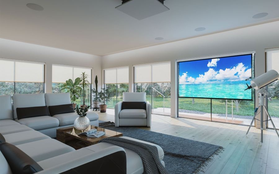 Media room with large floor-to-ceiling windows. Screen Innovations' shades are partially drawn and the movie screen reflects an image of the ocean. 