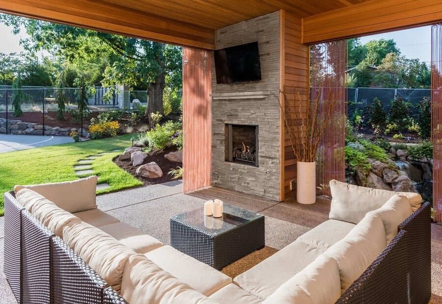 A backyard setup featuring an outdoor TV and seating.